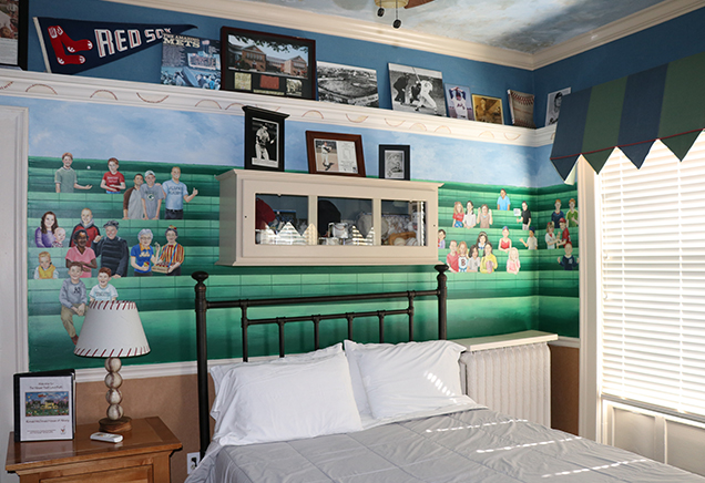 Bedroom with custom mural depicting baseball stands with fans in the bleachers and baseball memorabilia around the room.