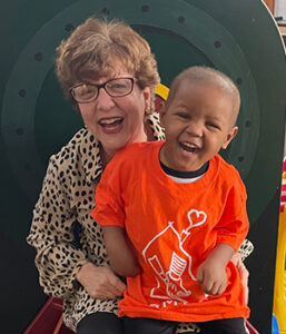 Resident House Director Debbie Ross laughs with a child at the Albany Ronald McDonald House