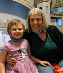 RMHC Volunteer Ellen Strait with a child in the Royal Retreat room at the Albany Ronald McDonald House