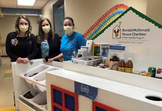 Three female hospital workers pose with the RMHC Hospitality Cart at Albany Med during COVID-19