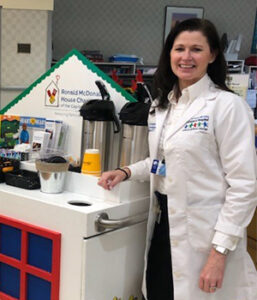 PICU Nurse Manager Janis Koshgarian stands beside the RMHC-CR Hospitality Cart at Albany Med