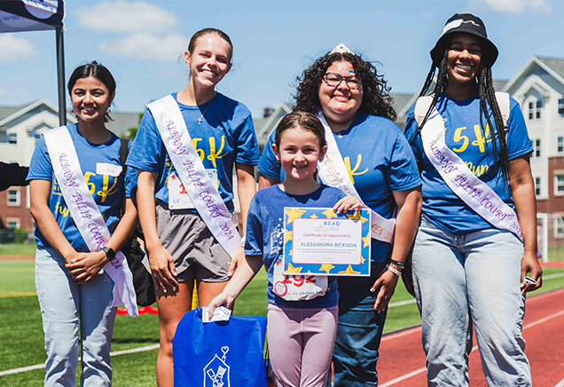 Student receiving a READ for RMHC award from the Albany Tulip Court at the 2024 5K Fun Run & Birthday Bash