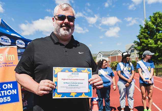 Principal receiving a READ for RMHC award at the 2024 5K Fun Run & Birthday Bash